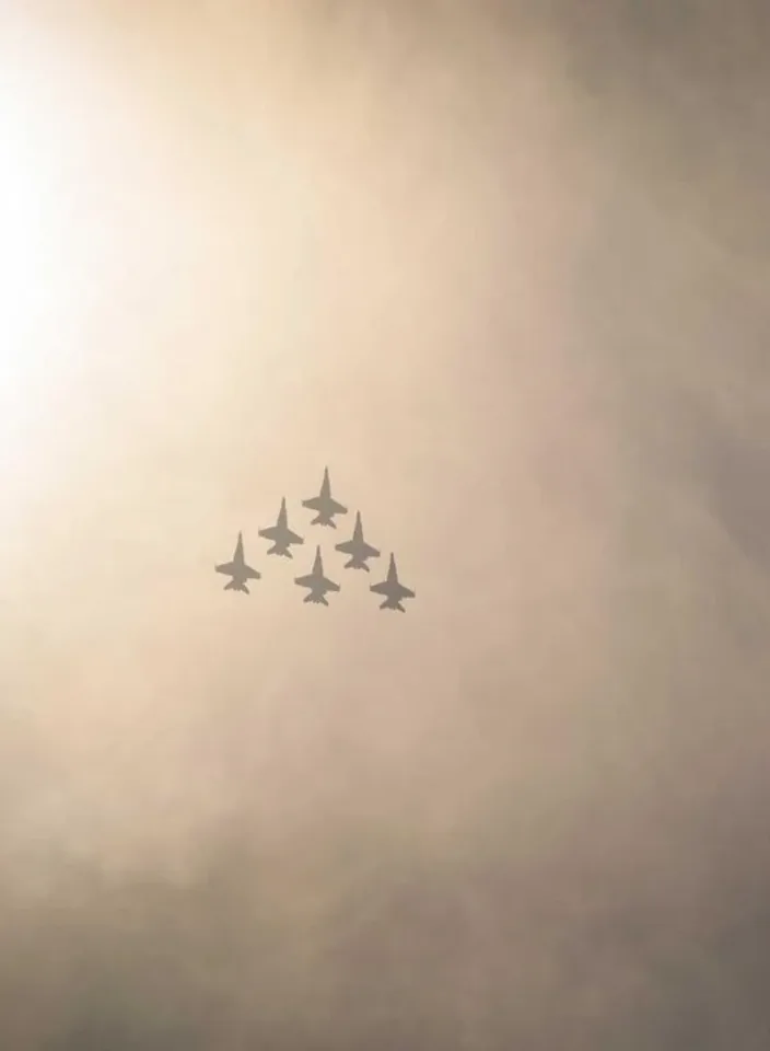 A formation of jets banking through hazy golden sky