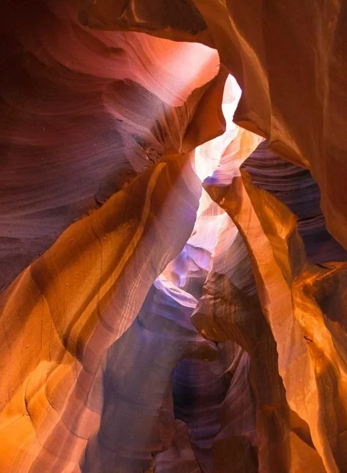 Orange sandstone walls curving through a narrow slot canyon