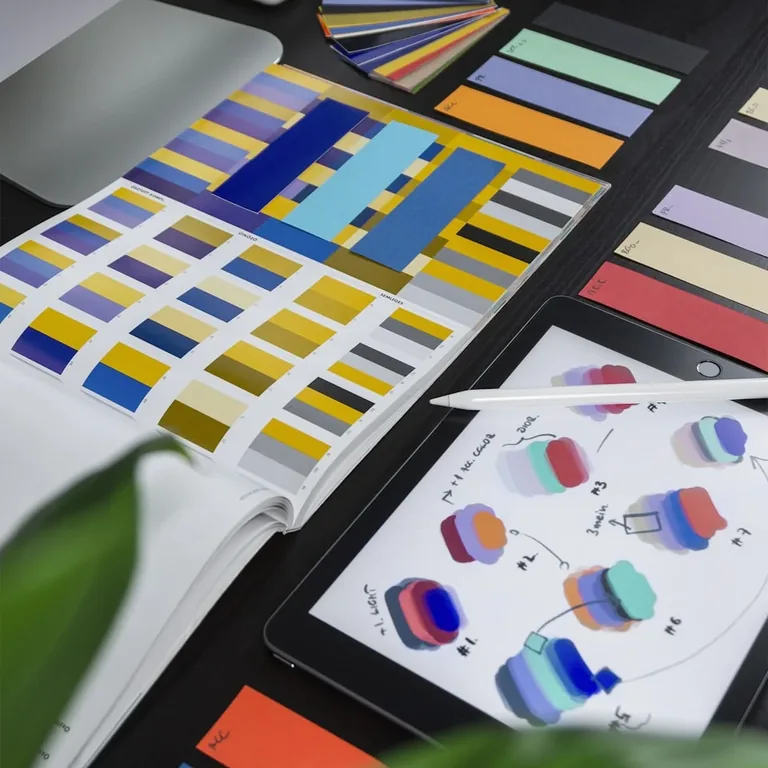 Colour swatch fans and printed design boards laid out on a desk