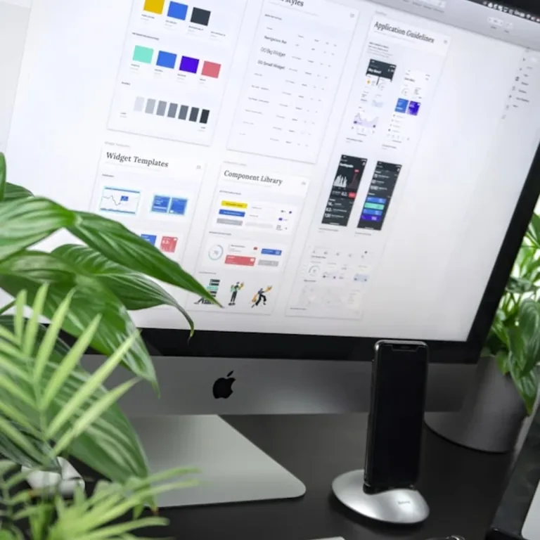 A desktop screen showing a design system, a plant leaning in beside it