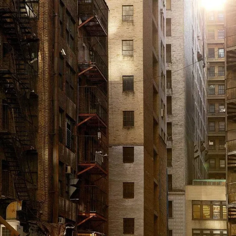 Dense weathered apartment facades stacked in warm evening light